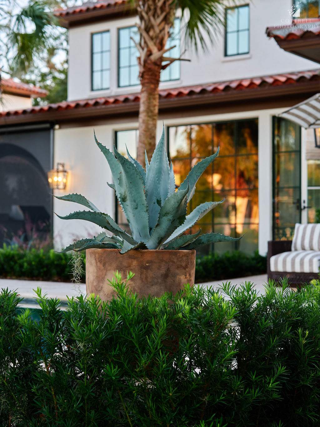 Exterior shot of a Spanish style home with a large planter