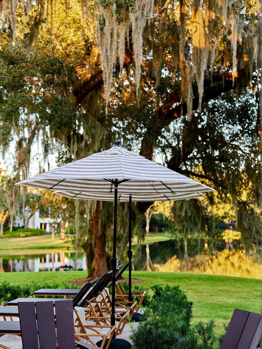 Chairs under an umbrella overlooking a lake